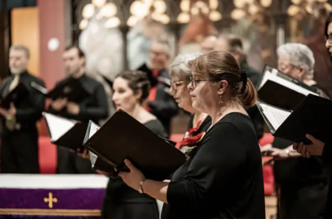 A holiday choir performance with an older caucasian woman as the focal point